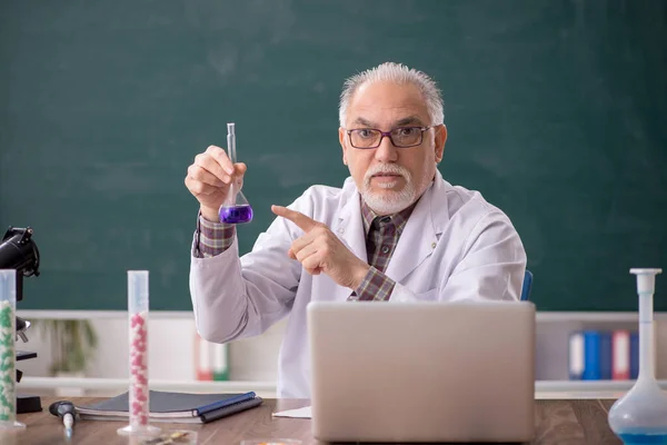教室に座っていた古い先生の化学者 — ストック写真