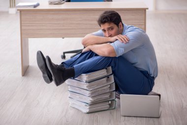 Young employee unhappy with excessive work at workplace