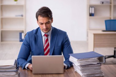 Genç işadamı işyerinde oturuyor.