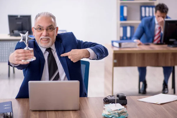 Two male employees with star award in the office