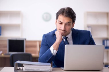 Genç işadamı ve işyerinde çok fazla iş var.