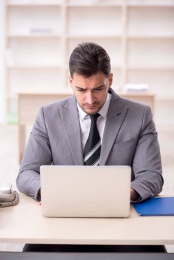 Genç işadamı işyerinde oturuyor.