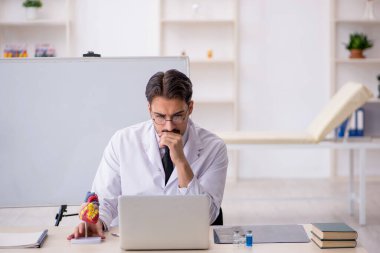 Genç doktor kardiyolog beyaz tahtanın önünde.