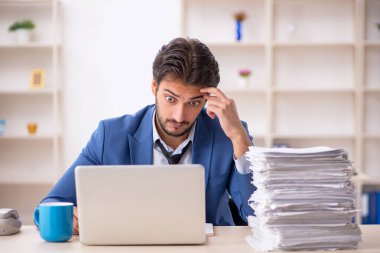 Genç işadamı ve ofiste çok fazla iş var.