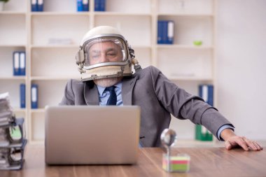 Old employee wearing spacesuit in the office