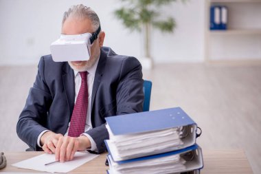 İş yerinde sanal gözlük takan eski bir çalışan.