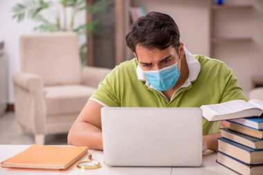 Genç öğrenci salgın sırasında evde sınavlara hazırlanıyor.