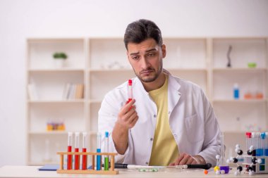 Young chemist sitting at the lab