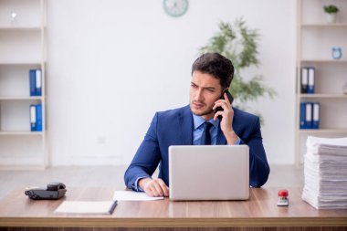 Genç bir çalışan ve ofiste çok fazla iş var.