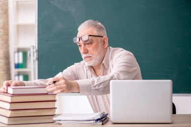 Old teacher sitting in the classroom