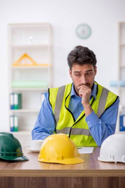 Genç mimar işyerinde oturuyor.