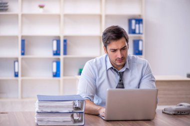 Ofisteki aşırı işten memnun olmayan genç bir çalışan.