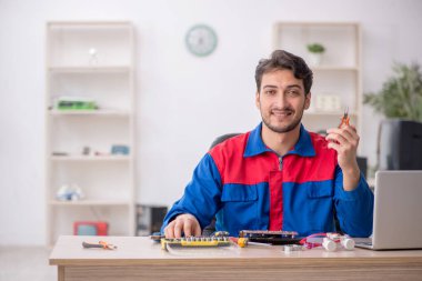 Laboratuvarda bilgisayar tamir eden genç bir tamirci.