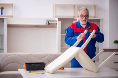 Old repairman repairing chair at home