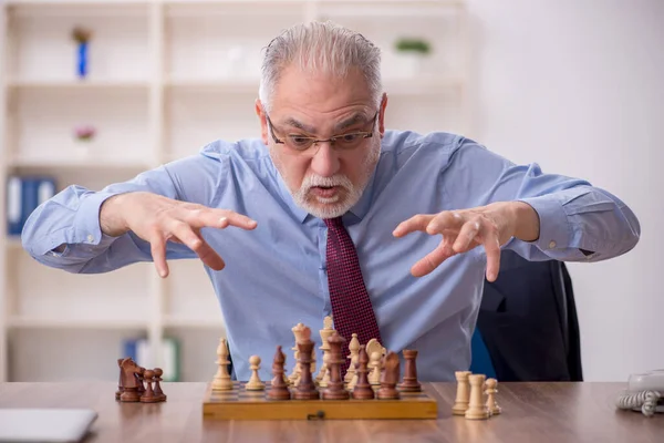 オフィスでチェスをしている古い男性従業員 — ストック写真