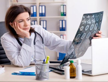 Klinikte çalışan yaşlı kadın doktor.