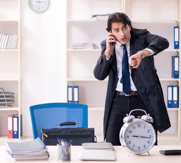 Stock image The young male employee in the office in time management concept