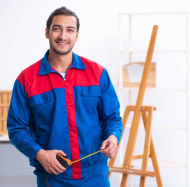 Atölyede çalışan genç bir erkek müteahhit.