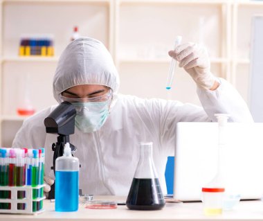 Laboratuvarda çalışan genç yakışıklı kimyager.