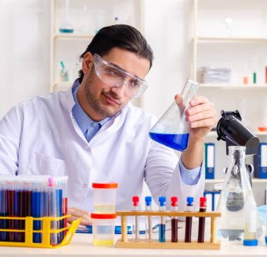 Laboratuvarda çalışan genç erkek kimyager.