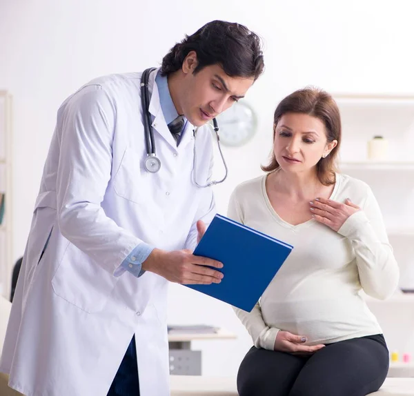 Ηλικιωμένη Έγκυος Γυναίκα Επισκέπτεται Νεαρό Άνδρα Γιατρό — Φωτογραφία Αρχείου