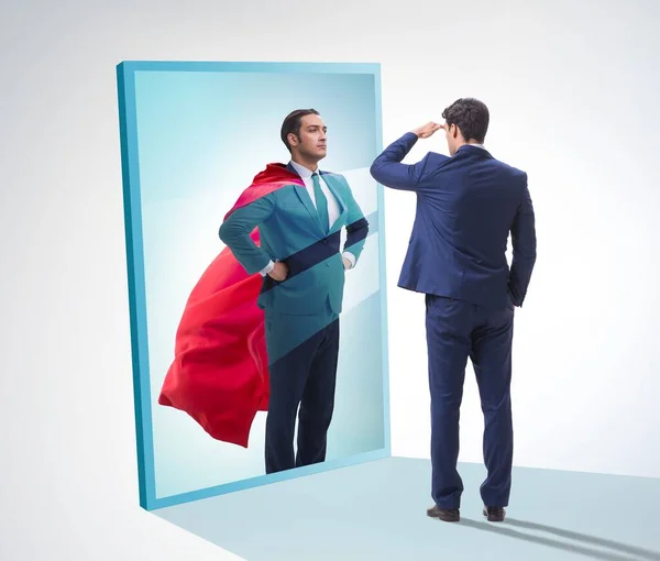 The businessman seeing himself in mirror as superhero