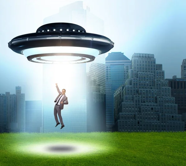 若いビジネスマンを誘拐した空飛ぶ円盤 — ストック写真