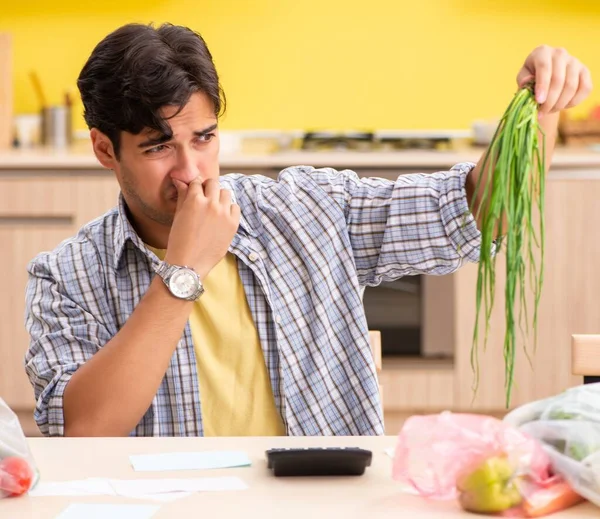 若い男は台所で野菜の経験を計算する — ストック写真