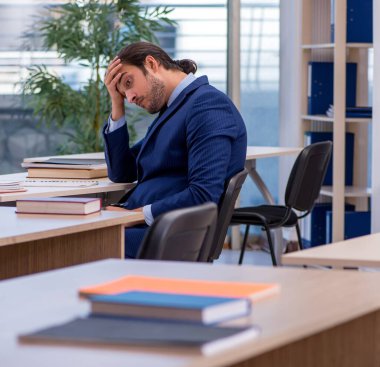 Sınıfta takım elbiseli bir öğretmen var.