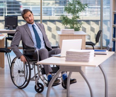Ofiste çalışan tekerlekli sandalyede çalışan genç bir çalışan.