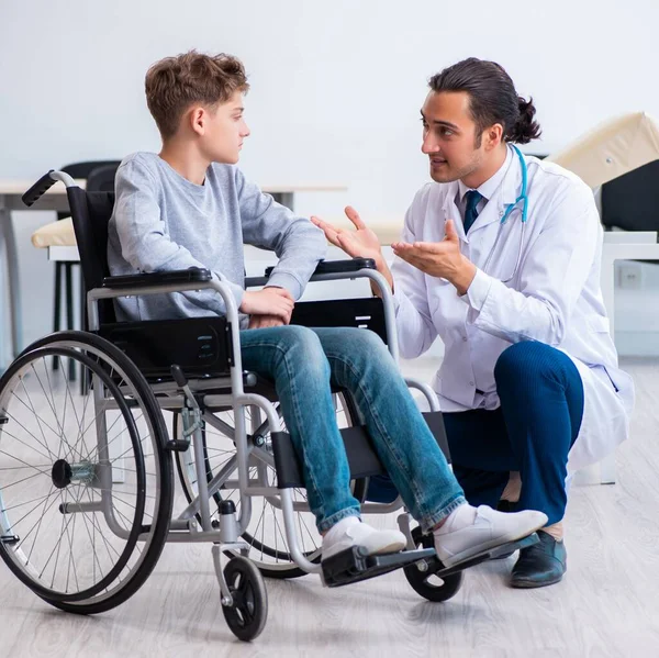Genç Erkek Doktor Pediatrist Tekerlekli Sandalyedeki Çocuk — Stok fotoğraf