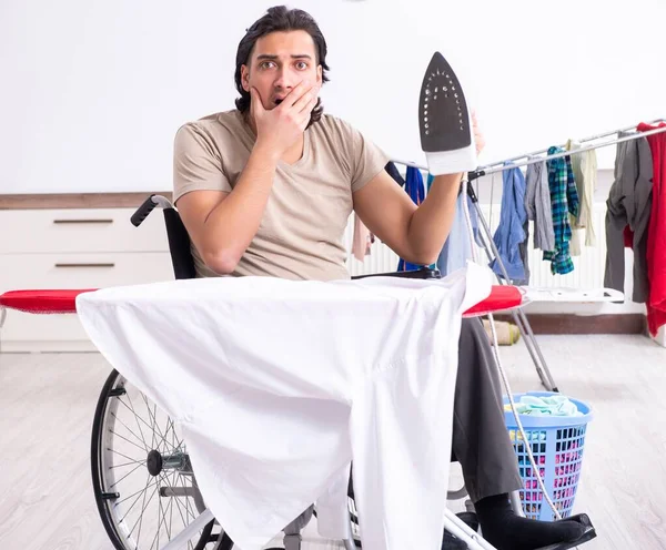 Νεαρός Την Αναπηρική Καρέκλα Σιδερώνει Στο Σπίτι — Φωτογραφία Αρχείου