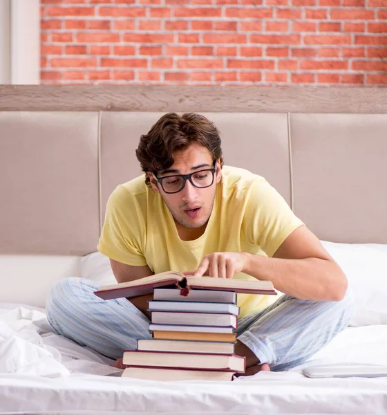 Νεαρός Φοιτητής Που Σπουδάζει Στο Κρεβάτι Για Εξετάσεις — Φωτογραφία Αρχείου