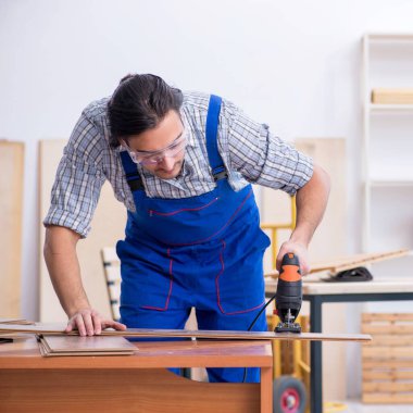 İçeride çalışan genç erkek marangoz.