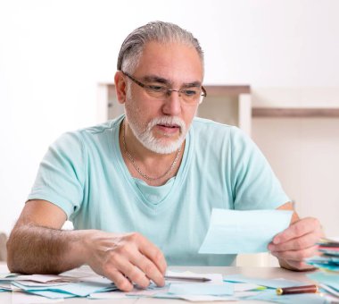 Bütçe planlama konseptinde beyaz sakallı yaşlı adam.