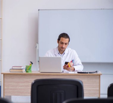 Genç doktor sınıfta seminer veriyor.