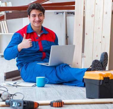 Dizüstü bilgisayarı olan genç marangoz.