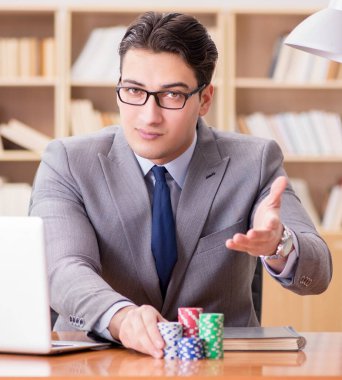 İşadamı iş yerinde kumar oynuyor.