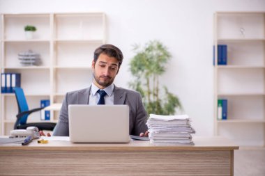 Genç işadamı ve işyerinde çok fazla iş var.