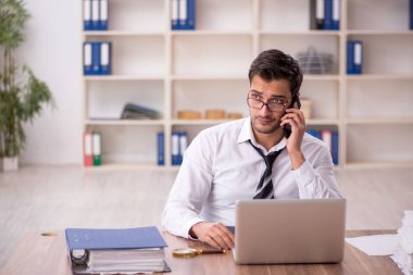 Genç işadamı işyerinde oturuyor.