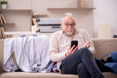 Aged man preparing for trip at home