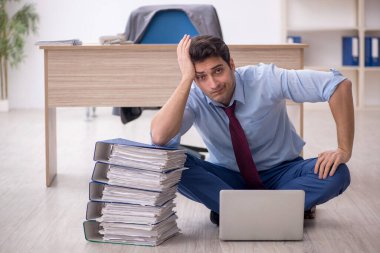Young employee unhappy with excessive work at workplace