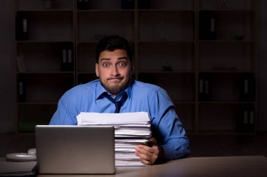 Young employee working late at workplace