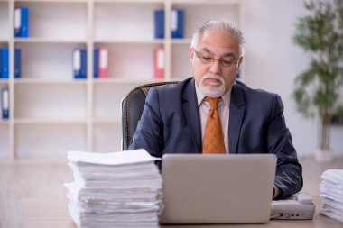 Ofisteki aşırı işten memnun olmayan eski bir işadamı.