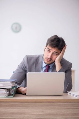 Young employee unhappy with excessive work at workplace