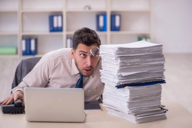 Young employee and too much work at workplace