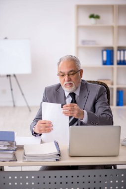 Ofiste çalışan eski bir işadamı.