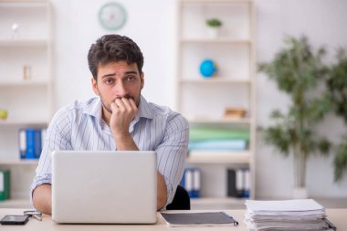 Genç çalışan işyerinde oturuyor.