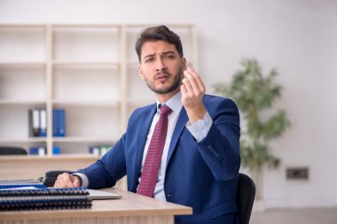 Genç işadamı işyerinde oturuyor.