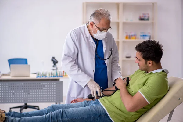 Alter Arzt Misst Jungen Patienten Den Blutdruck — Stockfoto